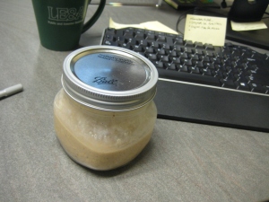 overnight oats in ball jar on desk with computer
